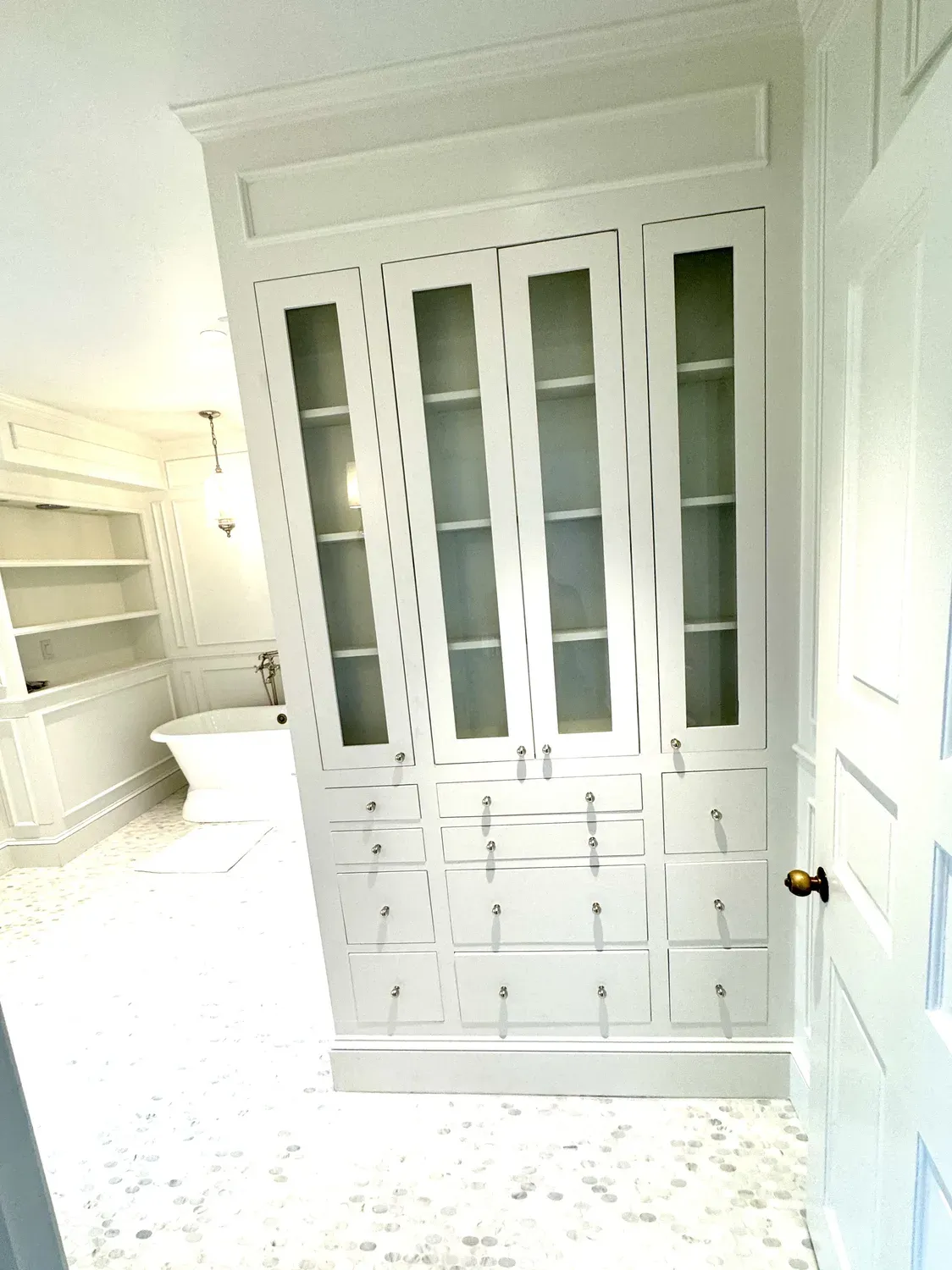 Custom built-in cabinetry with glass-front doors by Building America Construction